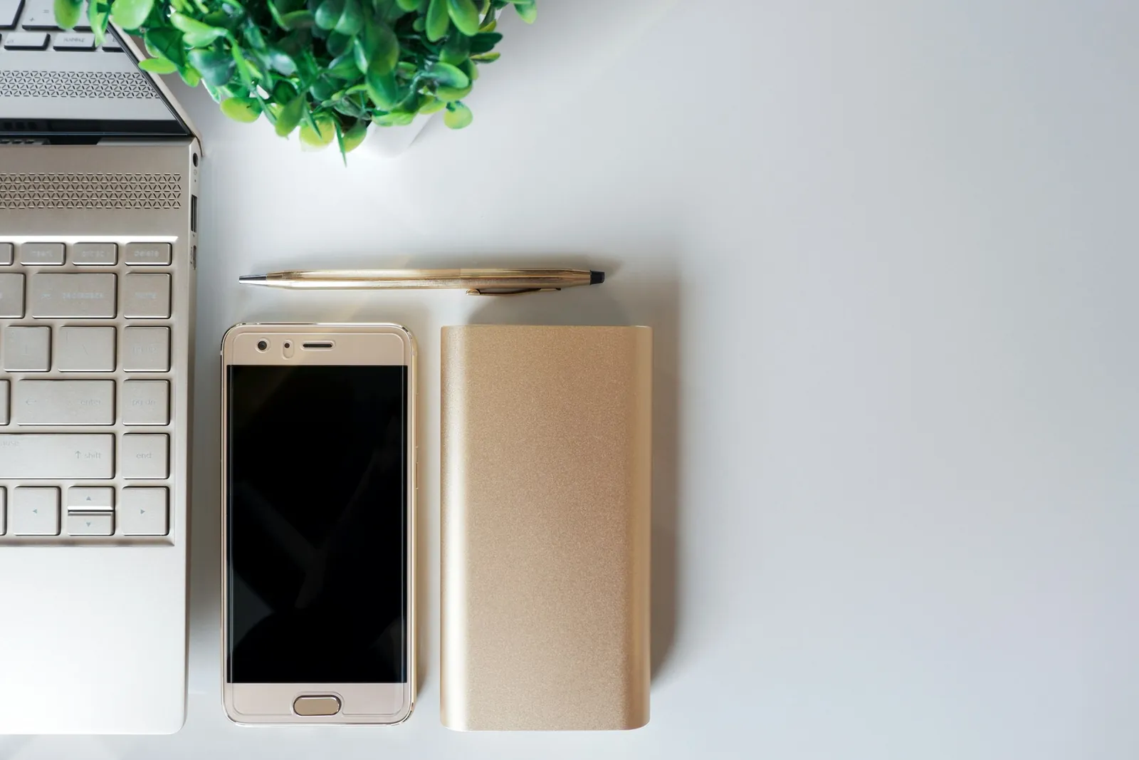 A laptop phone and notebook on a desk