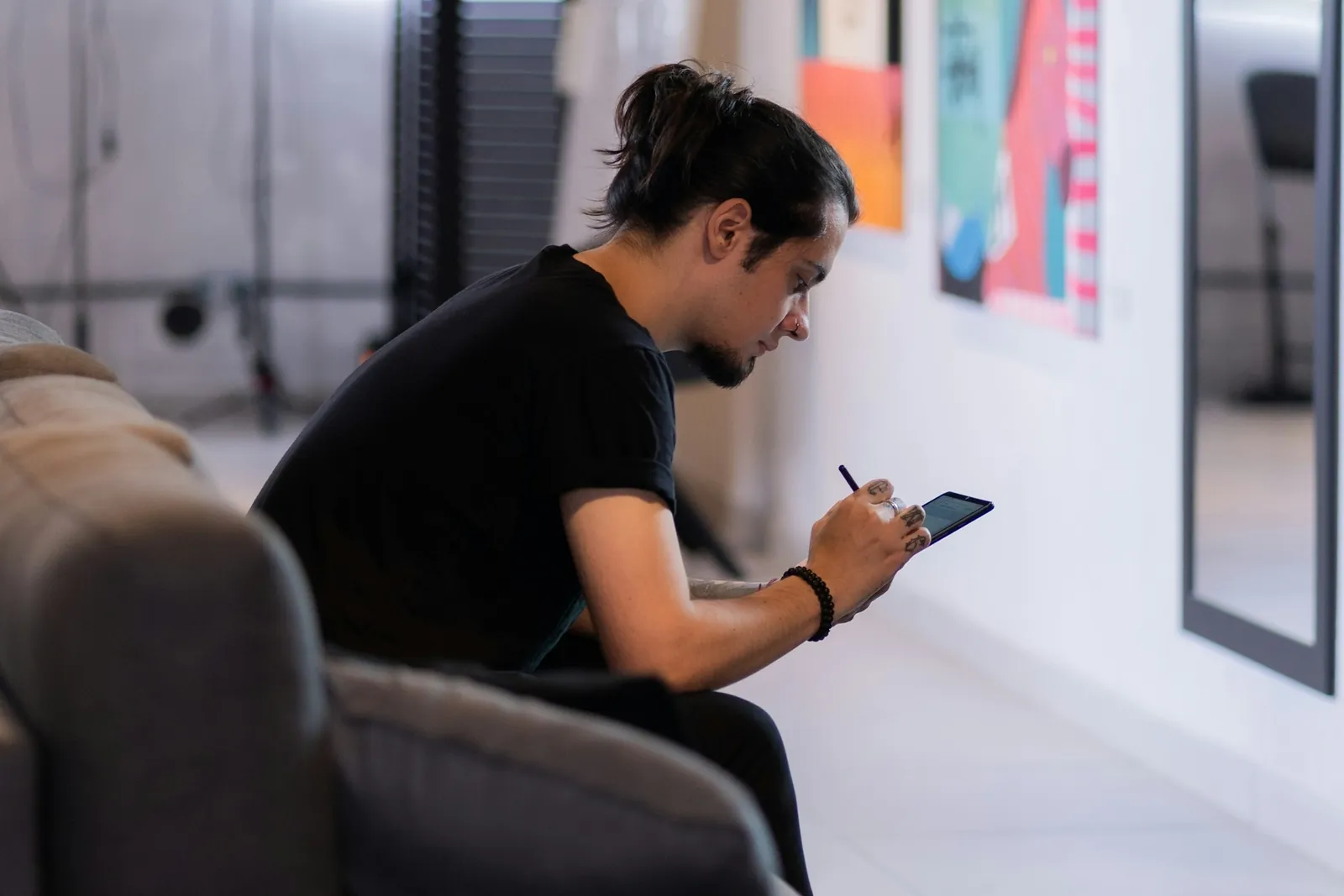 A person sitting on a couch looking at a tablet