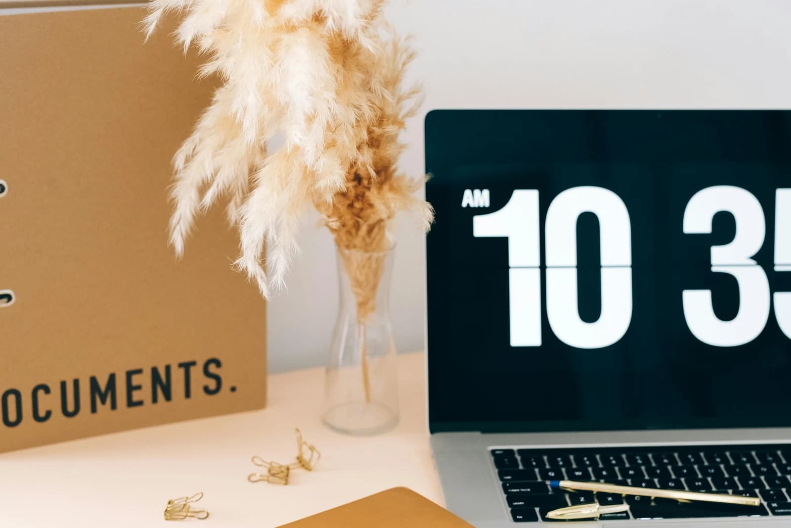 A documents folder next to a laptop on a desk