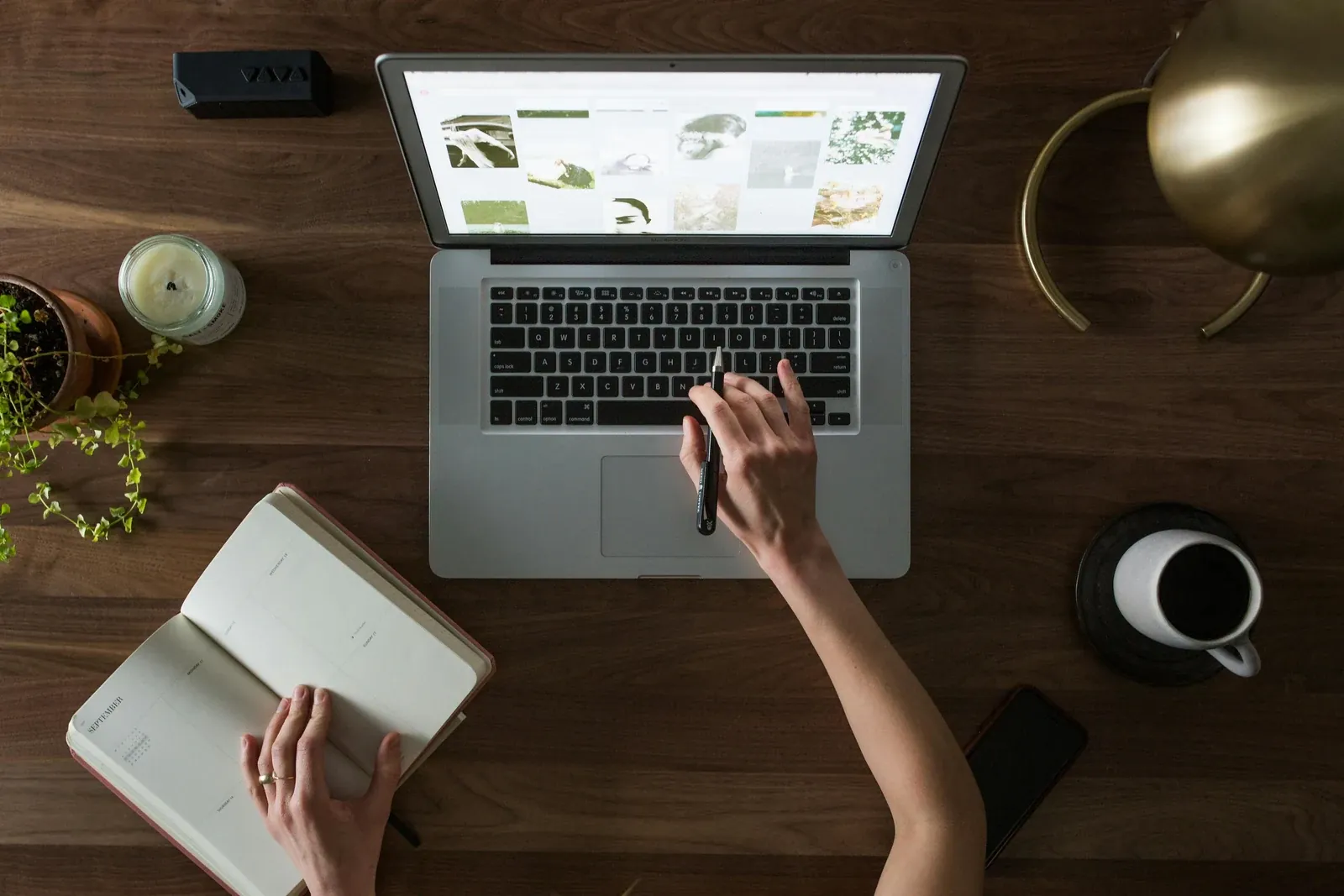 Top-down view of a person working on a laptop at a wooden desk