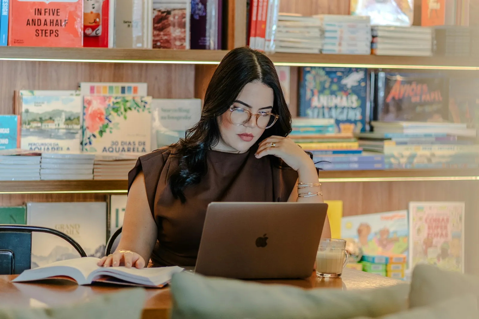 Student using a laptop beside books while reading a digital textbook