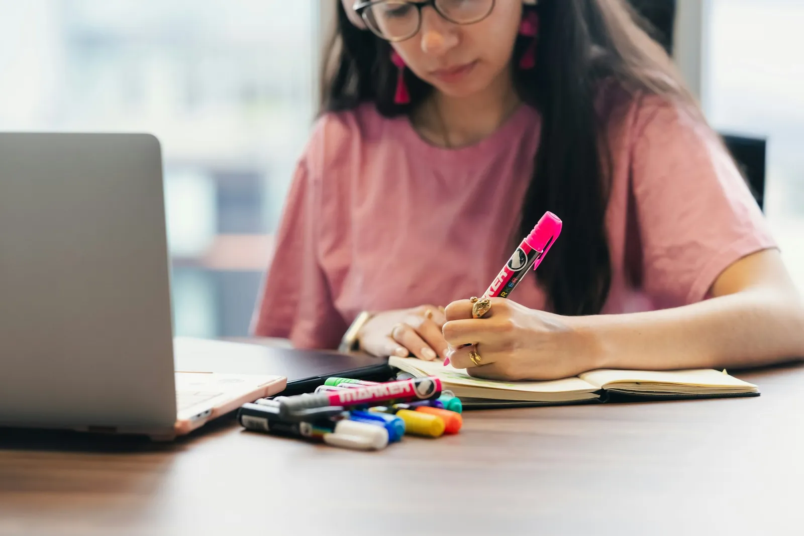 Student comparing notes and a digital textbook on a laptop