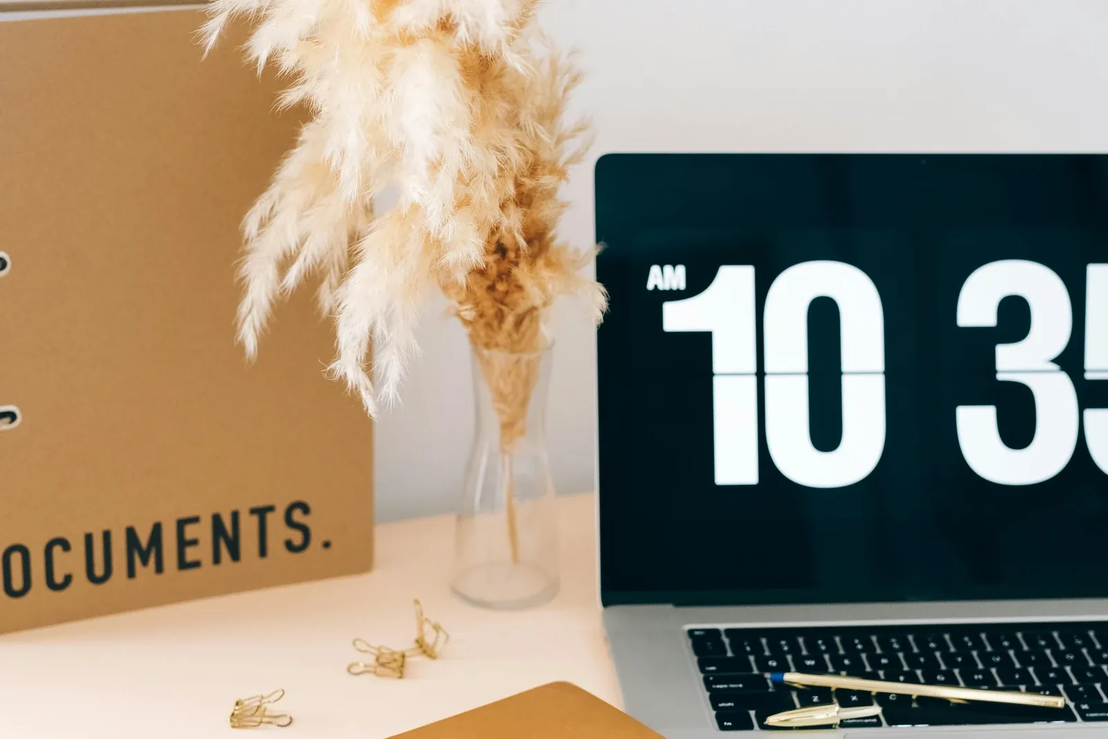 Documents, notebook, and laptop arranged on a desk