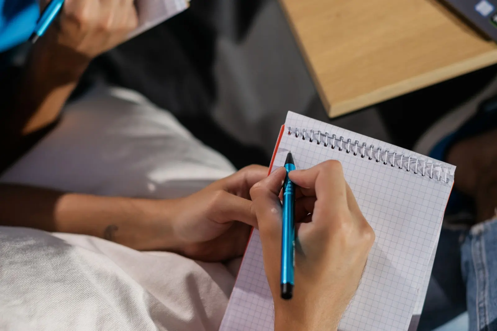 A person marking items in a notebook checklist